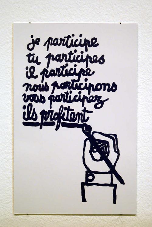 Sur l'affiche, est dessinée une main qui a écrit "je participe, tu participes, il participe, nous participons, vous participez, ils profitent" et cette dernière phrase est soulignée par la main.